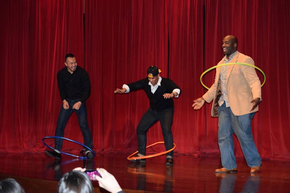 Three people using hula hoops on stage