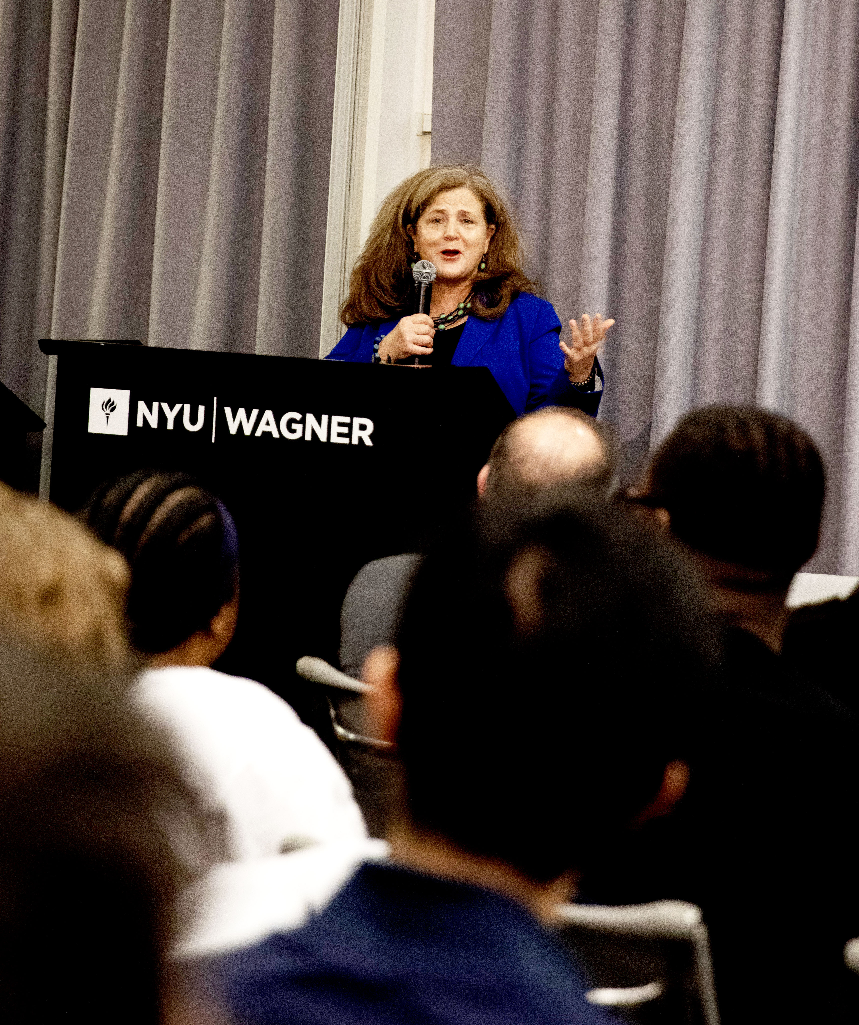 woman in blue suit holding a microphone