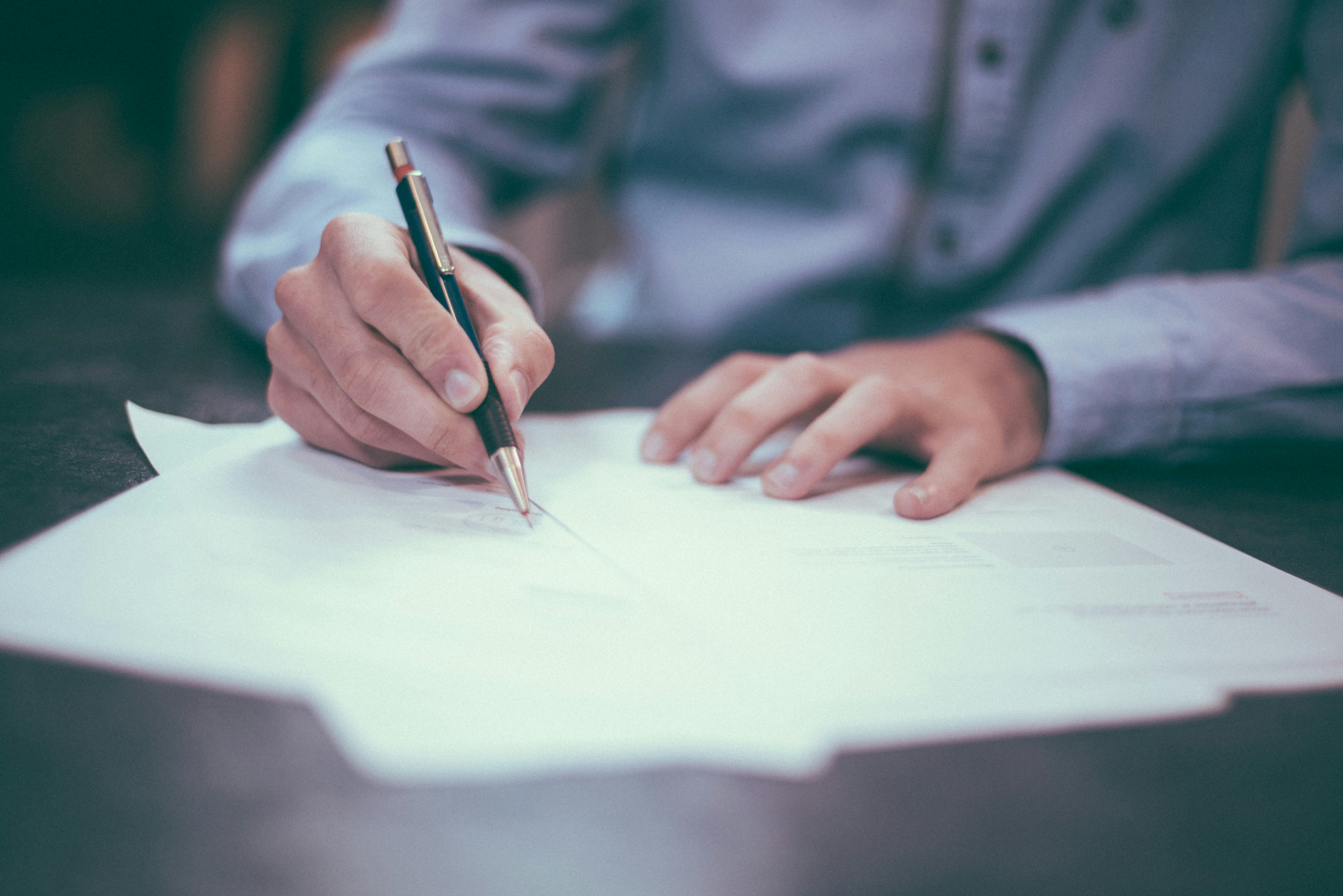 hand with pen signing paper