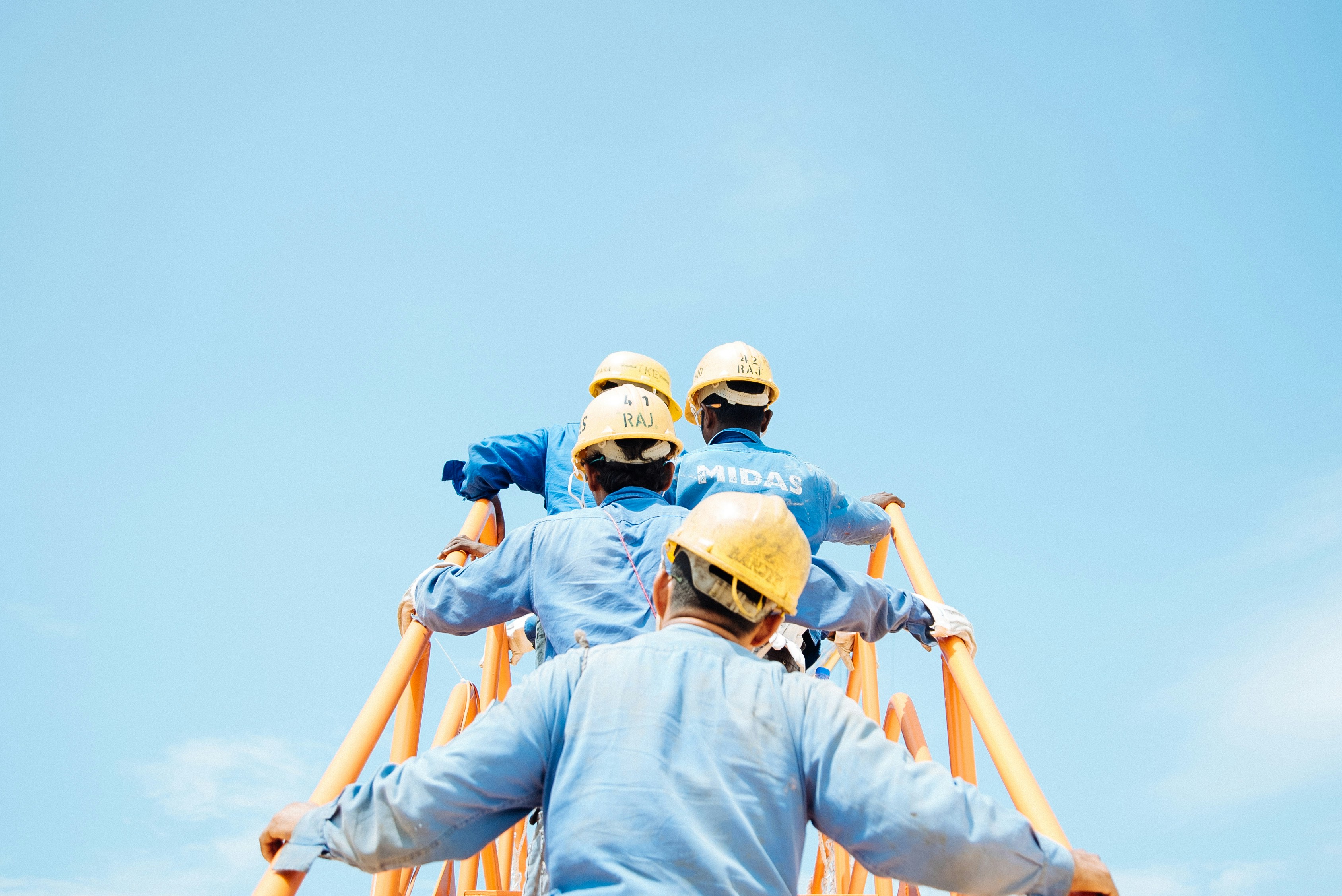 people in construction helmets climbing stairs