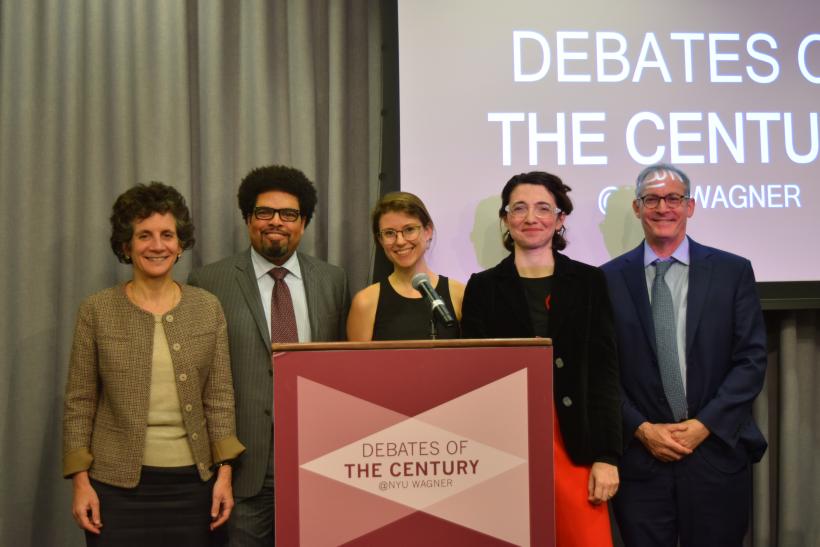 Event debaters and hosts pictured on stage. 
