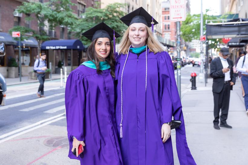 Two graduates outside City Center