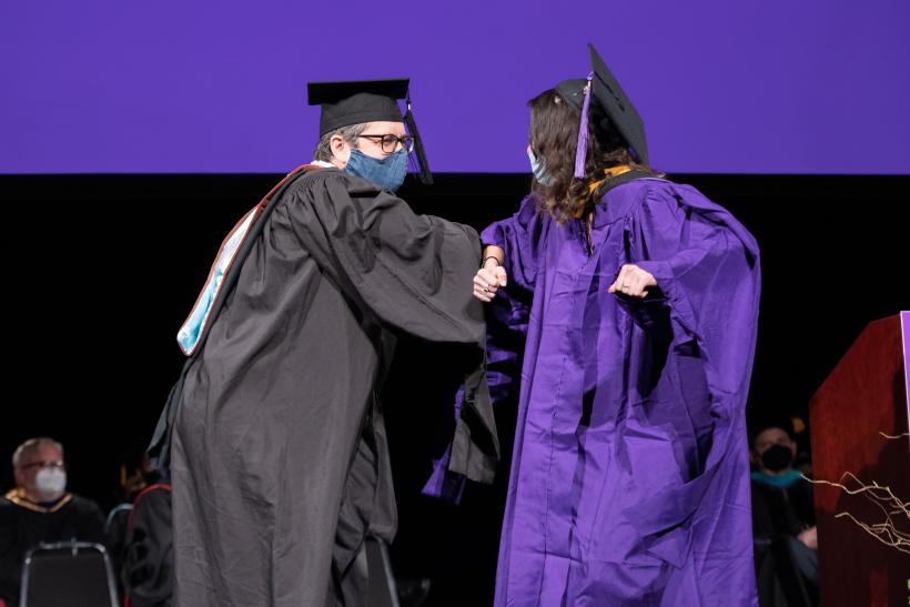 Graduate being greeted by faculty memeber