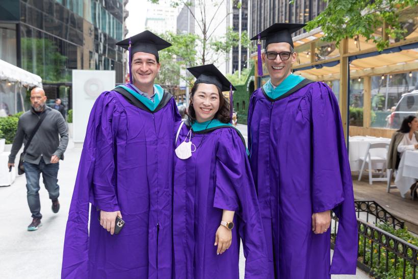 Three graduates outside City Center
