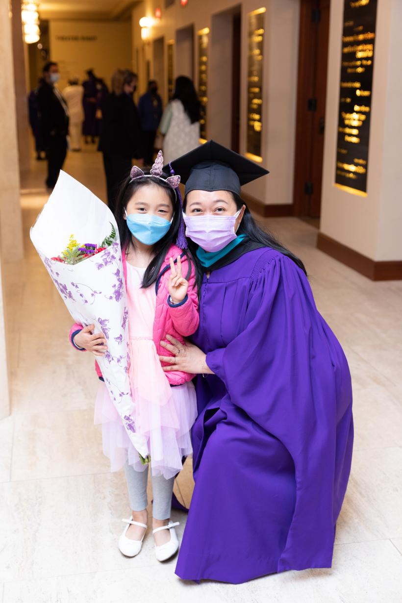 A graduate with a child inside City Center