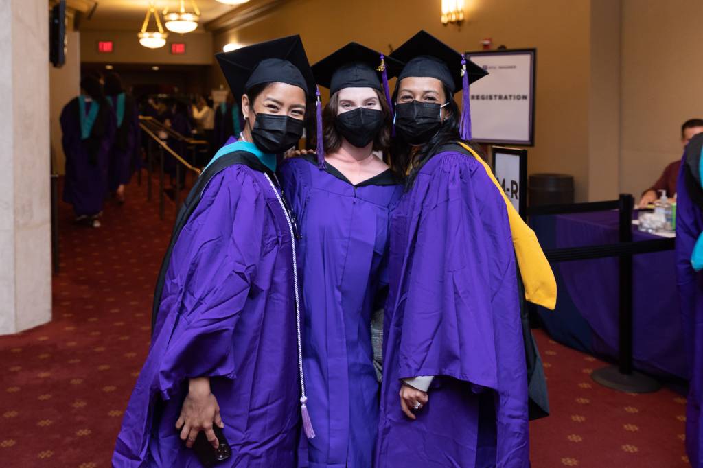 Three graduates inside City Center