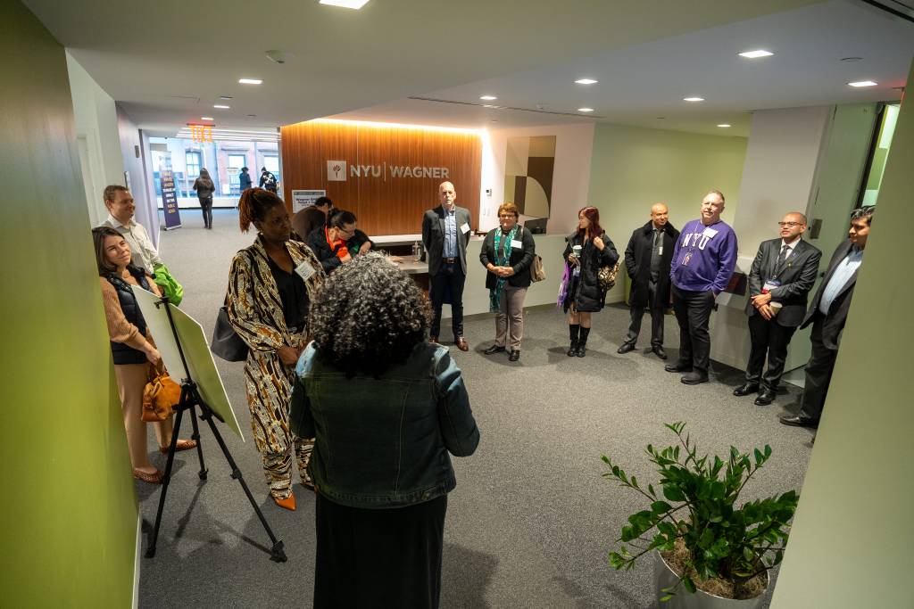 group of people standing in a circle listening to a person speaking