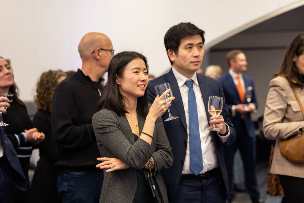 two people standing holding wine glasses 