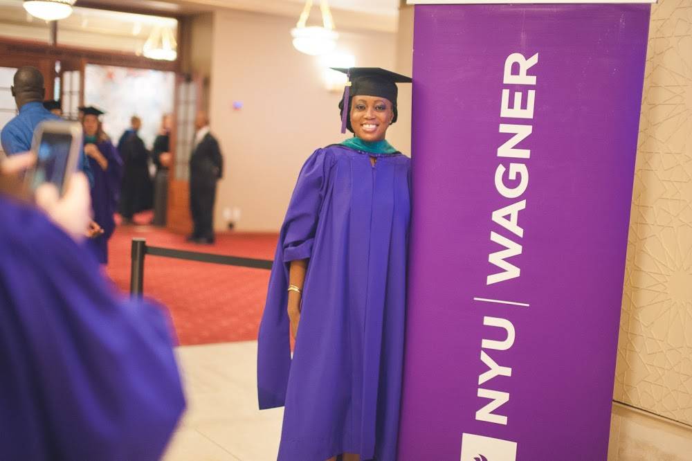 Student standing next to NYU Wagner sign