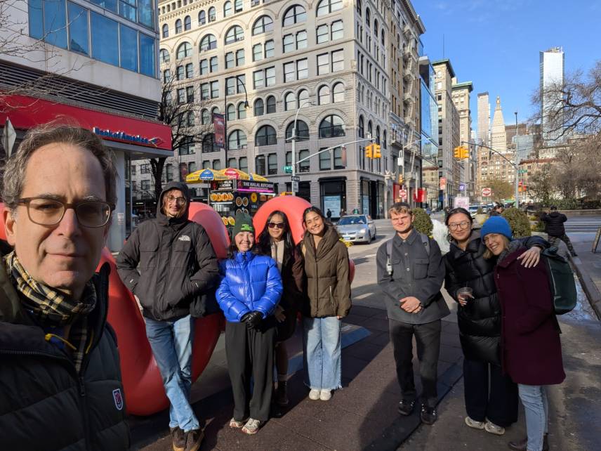 group of students posing for photo on city street 