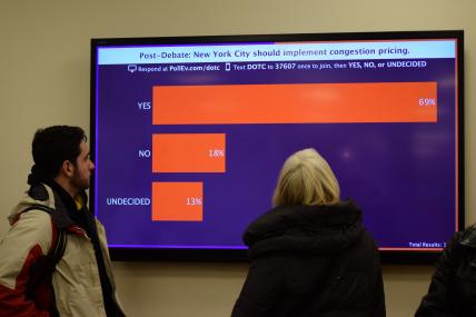 A woman looks at the screen with the results of the closing poll.