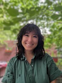 Pictured is a headshot of a young woman with medium length curly hair. 