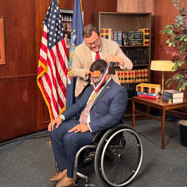 Quemuel Arroyo receiving an award by State Senator Luis R. Sepúlveda