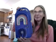 Alicia Polak in 2023 holding the same radio that impacted her journey over 20 years ago.