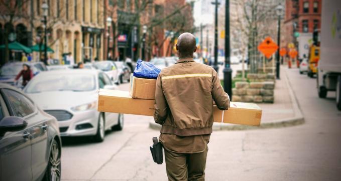 Delivery man with packages / Image via Unsplash